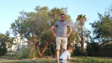 Sevimli çocuk plastik şişeden su içiyor ve babası ona vuruyor. Aile bağı
