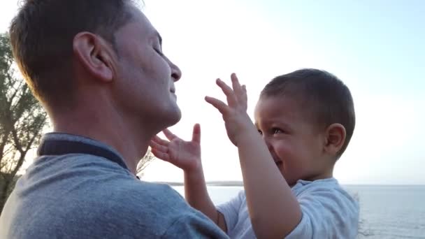 Young caucasian father holding his son toddler. Baby touching the face of his dad — Stock Video