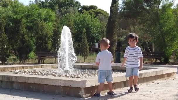 Adorables hermanos niños mirando la fuente, hermano niños caminando cámara — Vídeo de stock