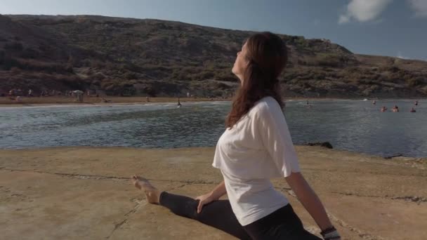 Een jonge vrouw die yoga beoefent. Voorste gespleten parallaxschot — Stockvideo