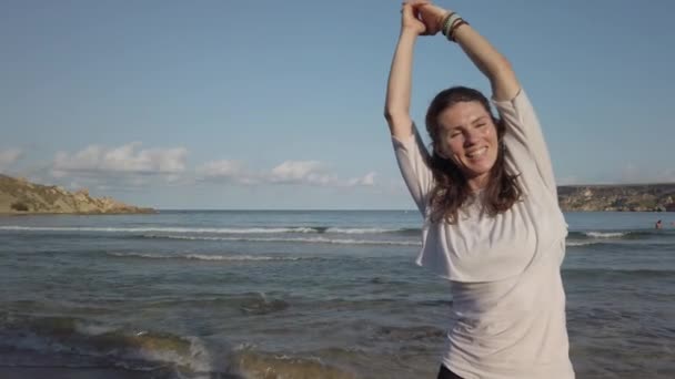 Mujer sensual joven practicando yoga en la playa de arena en la luz del sol dorada de la mañana eraly — Vídeos de Stock