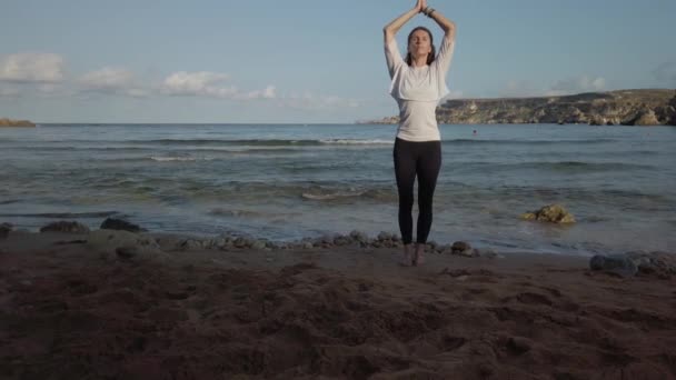 Mujer sensual joven practicando yoga en la playa de arena en la luz del sol dorada de la mañana eraly — Vídeo de stock