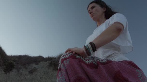 Низький кут. Молода жінка робить йогу, ашва сахаланана кінна попка, на піщаному пляжі рано вранці — стокове відео