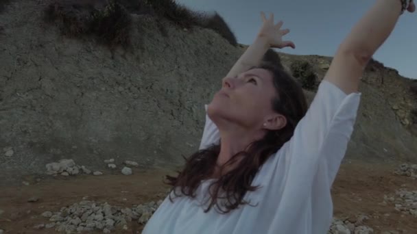 Молода біла жінка, брюнетка робить йогу на пляжі на початку осіннього ранку — стокове відео