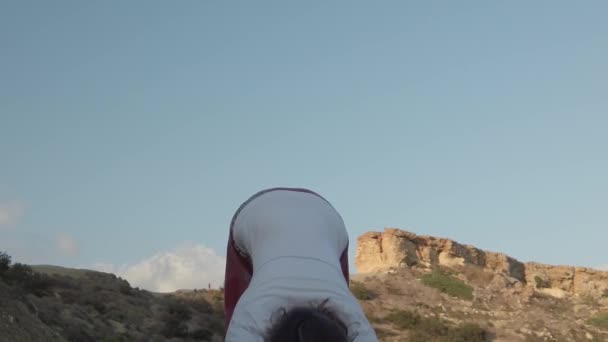 Femme dans les années 40 pratiquant le yoga sur la plage de sable tôt le matin. — Video