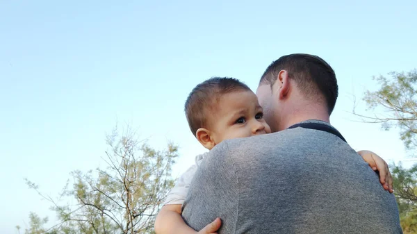 Un giovane padre caucasico che tiene in braccio suo figlio. Bambino toccare il volto di suo padre — Foto Stock