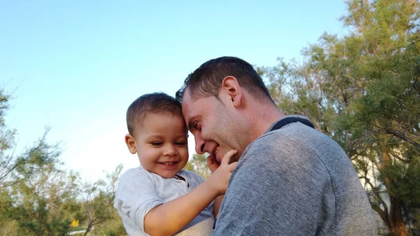 Jeune père caucasien tenant son fils tout-petit. Bébé touchant le visage de son père — Photo