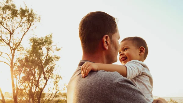 Mladý bělošský otec drží svého syna batole. Dítě dotýkající se tváře svého otce — Stock fotografie