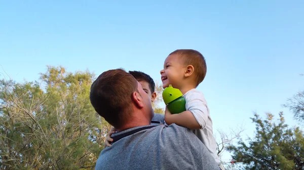 Un jeune père embrassant ses fils dans le parc. Concept de famille heureuse — Photo