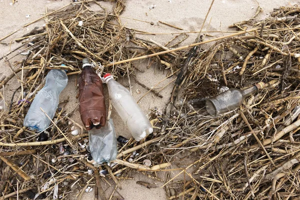 Мусор на пляже. Пустые пластиковые и стеклянные бутылки на песке. Загрязнение окружающей среды Спаси планету. Экологическая проблема. Грязная береговая линия. Природа . — стоковое фото