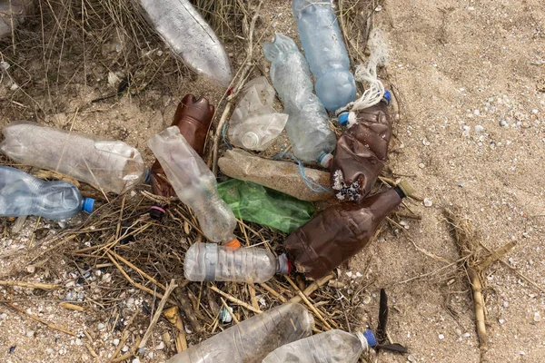 Пустые пластиковые бутылки на песке. Мусор на пляже. Грязный морской берег. Загрязнение окружающей среды Спаси планету. Экологическая проблема. Природа . — стоковое фото