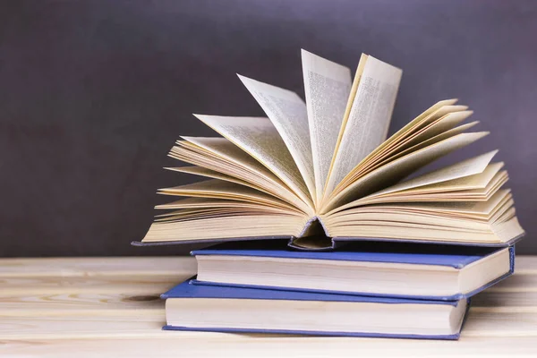Ahşap raftaki eski kitaplar. Kapalı sayfaları olan açık bir kitap. Ev kütüphanesi. Korkunç bir hikaye. Klasik edebiyat. Okula dönelim. Eğitim geçmişi. Metin için alanı kopyala.