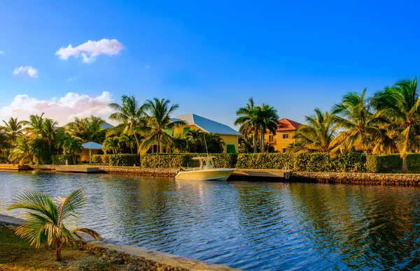Grand Cayman, Cayman Adası, Ocak 2019, batı körfezinde Karayip Denizi'ne giden bir kanal üzerinde gün batımında bir yerleşim bölgesinde demirlemiş tekne 