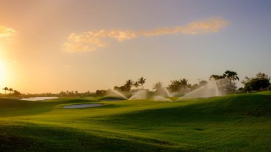 Grand Cayman gün batımında Golf sahası sulanıyor, Cayman Adaları