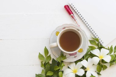 sıcak çay bitkisel içecekler ve defter ile ahşap beyaz arka plan üzerine beyaz frangipani