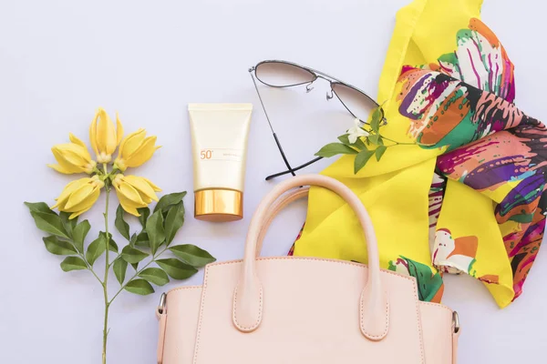 sunscreen spf50 ,pink bag,sunglasses and yellow scarf accessories of lifestyle woman relax on background white