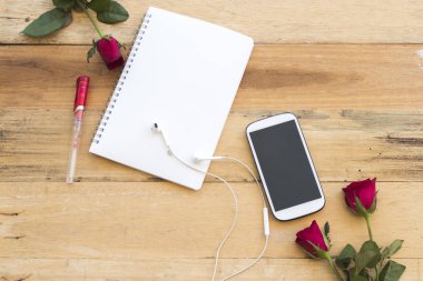 cep telefonu ve dizüstü bilgisayar planlayıcısı ile zemin ahşap üzerine gül çiçek