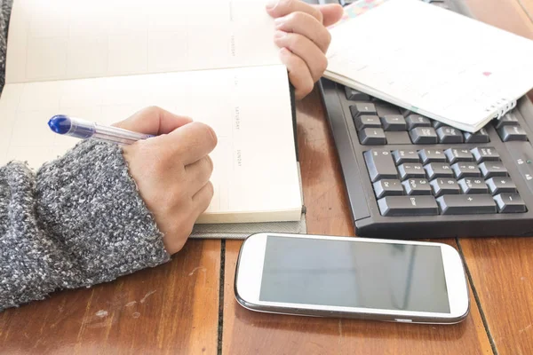 El çalışan kadın defter planlayıcısı ve iş ofis masası, bilgisayar ile