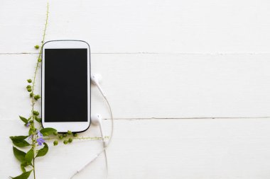 cep telefonu kulaklık ile arka plan üzerinde ahşap bırakır
