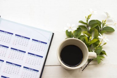 Asya Tayland arka plan ahşap beyaz iş için sıcak kahve ve defter Takvim Planlayıcısı ile yasemin beyaz çiçek