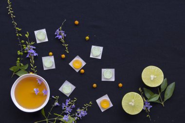 Boğaz pastil hapları bitkisel bal limon siyah arka plan üzerinde mor çiçek düzenleme ile gelen öksürük