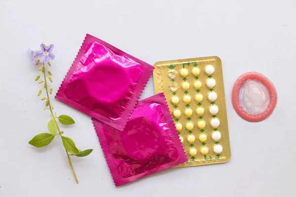 避孕丸的妇女不希望有与避孕套的人的健康护理的性别概念爱与安全的背景白色 — 图库照片