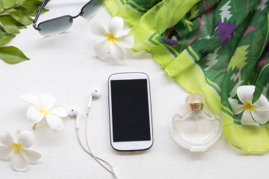 cep telefonu, güneş gözlüğü, parfüm ve yeşil yaşam tarzı kadın ile beyaz çiçek frangipani beyaz arka plan üzerinde renkli topluluğu eşarp