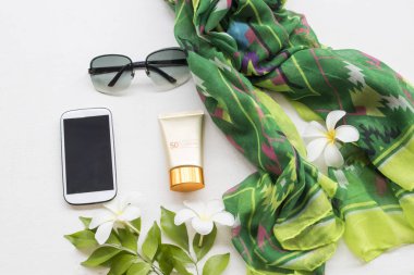 cep telefonu, güneş gözlüğü, Güneş kremi spf50 ve yeşil yaşam tarzı kadın ile beyaz çiçek frangipani beyaz arka plan üzerinde renkli topluluğu eşarp