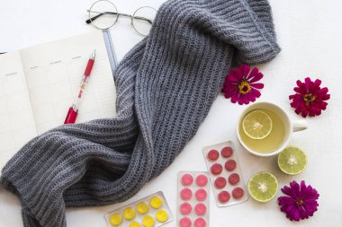 bal limon öksürük boğaz ağrısı hapları ve kış sezonu arka plan beyaz tahta üzerinde yaşam tarzı kadın için yün Atkı örgü ile defter planlayıcısı ile bitkisel sağlıklı içecekler