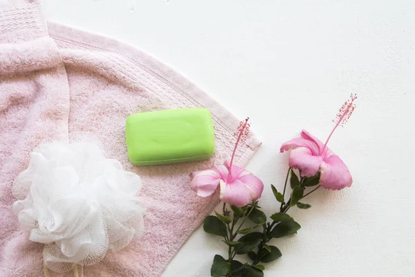 terry cloth , herbal soap for health care body skin with pink  flower hibiscus on background white wooden