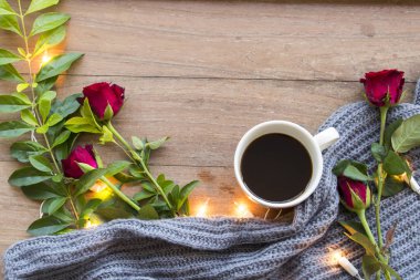 sıcak kırmızı gül desenli siyah kahve ve ışık, örgü atkı yaşam tarzı ahşap arka plan üzerinde kış sezonu için süsleyin