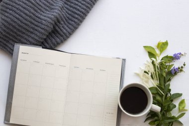 iş ve yaşam tarzı kadının yün Atkı örgü ile sıcak kahve için defter planlayıcısı kış sezonu ve mor çiçek rahatlayın, arka plan beyaz ışık süslemeleri