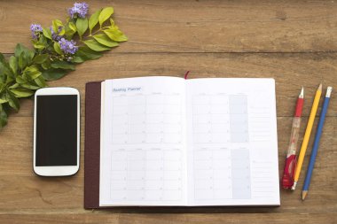 iş için defter planlayıcısı ofis masası ahşap arka plan üzerinde hareket eden telefon ile çalışmak