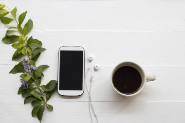 arka plan beyaz mor çiçek ile dinlenmek için sıcak kahve ile cep telefonu