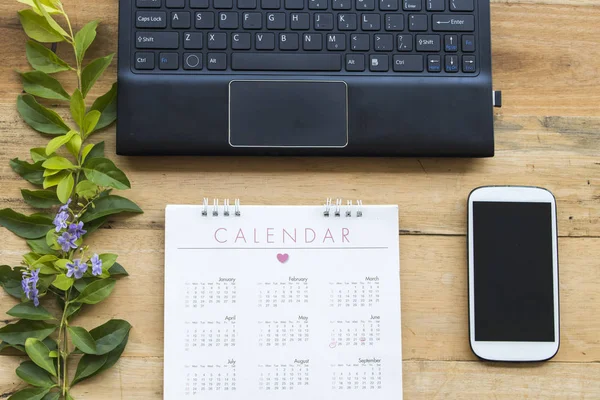 mobile phone  ,calendar ,computer for business work on background wooden at office desk