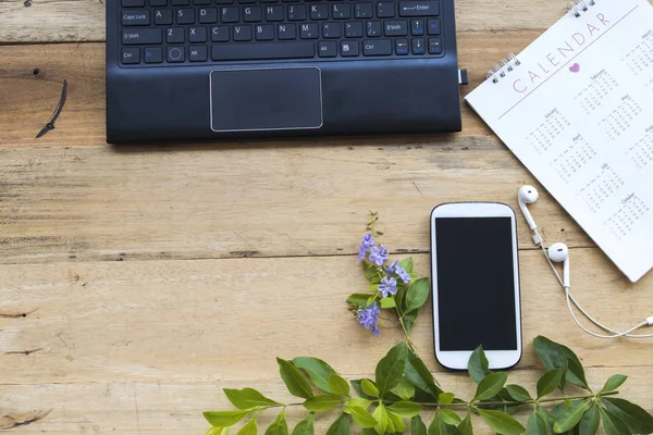 computer ,mobile phone ,calendar for business work on background  wood at office desk