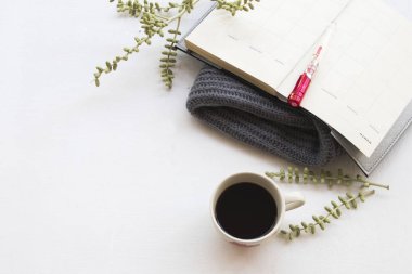iş için defter planlayıcısı işe sıcak kahve ve kış sezonu, ofis masası üzerinde arka plan beyaz yün Atkı örgü ile 