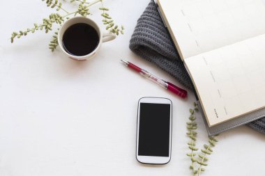 cep telefonu iş için defter planlayıcısı, işe sıcak kahve ve kış sezonu ofis masası beyaz arka plan üzerinde yün atkı, örgü 