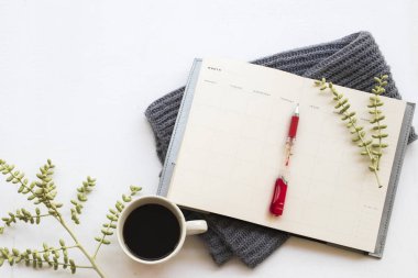 iş için defter planlayıcısı işe sıcak kahve ve kış sezonu, ofis masası üzerinde arka plan beyaz yün Atkı örgü ile 