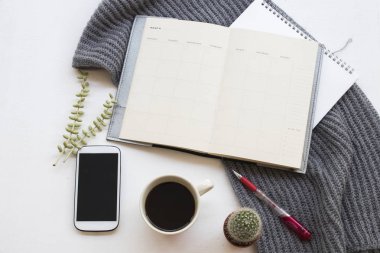 cep telefonu iş için defter planlayıcısı, işe sıcak kahve ve kış sezonu ofis masası beyaz arka plan üzerinde yün atkı, örgü 