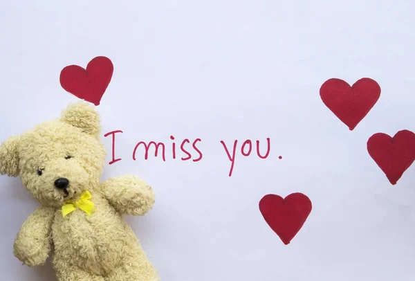 i miss you message card handwriting with draw red heart and teddy bear on paper white