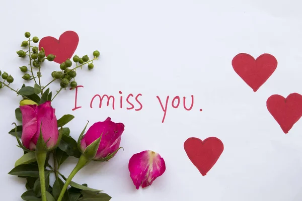 i miss you message card handwriting with draw red heart and pink rose flowers for special in valentine day on paper white