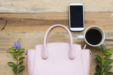 cep telefonu, sıcak kahve ve pembe el çantası yaşam tarzı kadının relax ahşap arka plan üzerinde