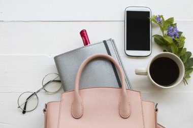 arka plan beyaz tahta üzerinde ofis masası, dizüstü bilgisayar planlayıcısı, cep telefonu ve pembe el çantası yaşam tarzı çalışma kadının iş için işe