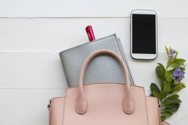 arka plan beyaz tahta üzerinde ofis masası, dizüstü bilgisayar planlayıcısı, cep telefonu ve pembe el çantası yaşam tarzı çalışma kadının iş için işe