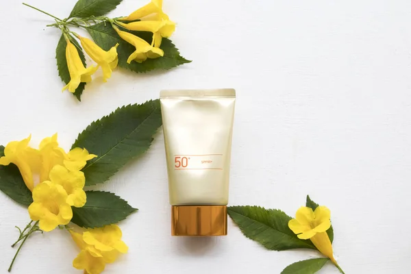 natural cosmetics for skin face sunscreen spf50 health care beauty protect of lifestyle woman with yellow flowers arrangement flat lay style on background white