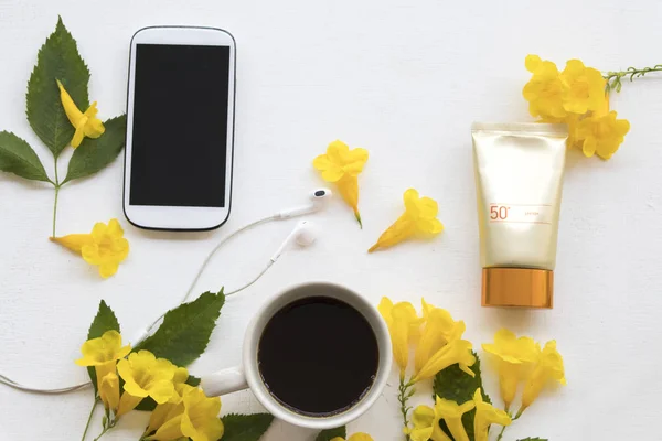 natural cosmetics for skin face sunscreen spf50 health care beauty protect of lifestyle woman with mobile phone ,coffee and yellow flowers arrangement flat lay style on background white