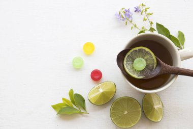 Boğaz ağrısı için bitkisel bal limon çay sağlıklı içecekler sağlık bakımı, pastil ve limon dilim beyaz arka plan üzerinde mor çiçek dekorasyonu ile