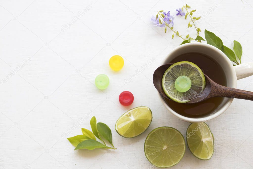 herbal honey lemon tea healthy drinks health care for sore throat ,lozenge and lemon slice with purple flowers decoration on background white