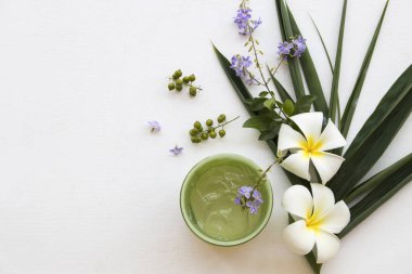 doğal bitkisel rahatlatıcı jel aroma özü yüz maskesi ayıklamak bambu güzellik cilt yüz sağlık yaprak kadınla bakımı için çiçek dekorasyon düz yatıyordu stili arka plan beyaz tahta üzerinde